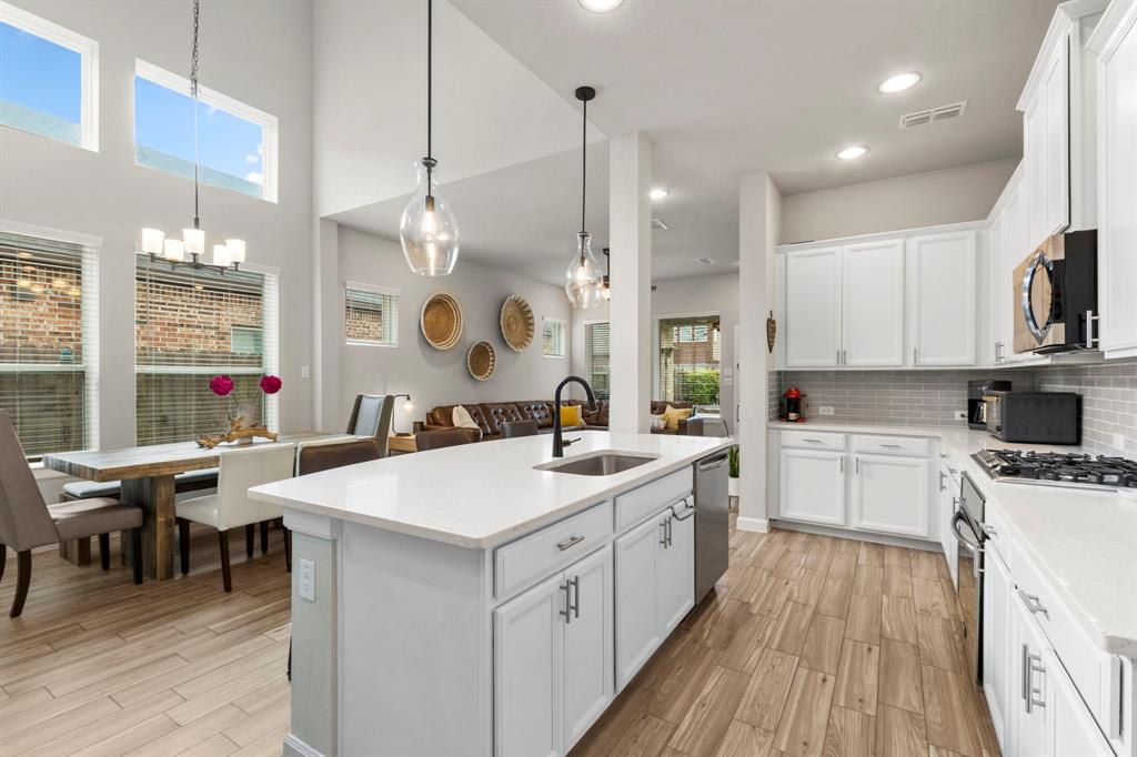 a large kitchen with kitchen island a white counter space a sink appliances and cabinets