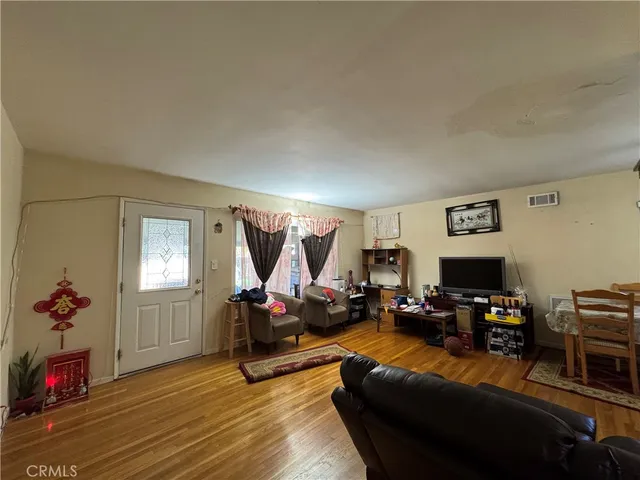 a living room with furniture flowerpot and wooden floor
