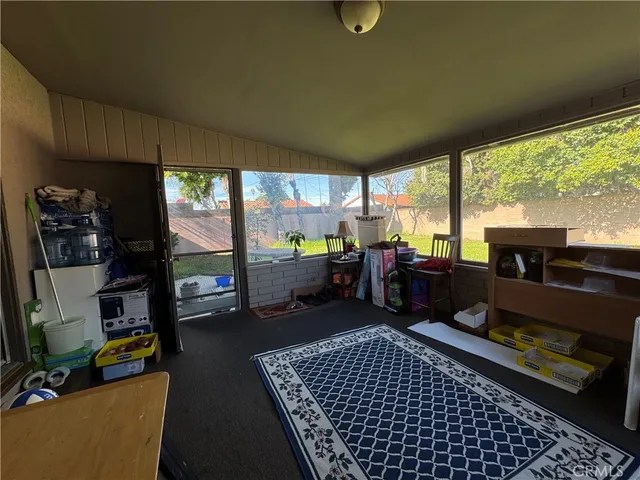 a living room with furniture a rug and a floor to ceiling window