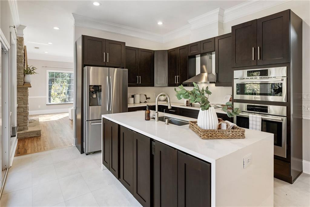 14440 Cogburn Road Alpharetta, GA 30004 - Photo 13 of 62 a kitchen with kitchen island granite countertop a sink refrigerator and cabinets