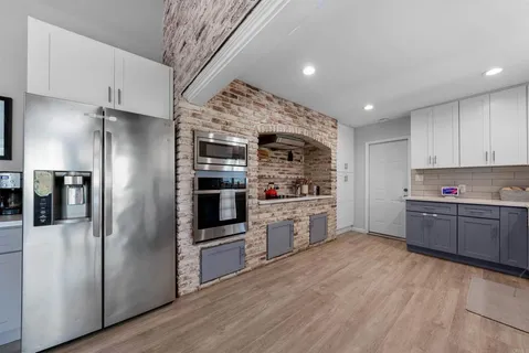 a kitchen with stainless steel appliances a refrigerator and a stove top oven