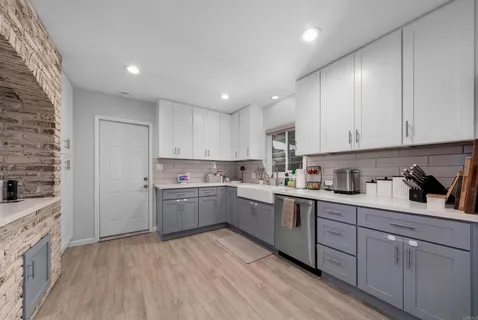 a kitchen with cabinets and wooden floor