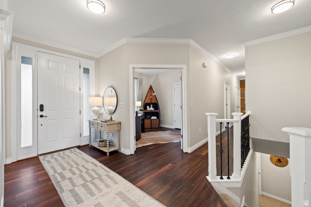 6208 West Bull River Road Highland, UT 84003 - Photo 12 of 90 Entryway featuring wood-finish flooring, a white paneled front door with sidelights, crown molding, and a staircase with white newel posts and wrought iron balusters