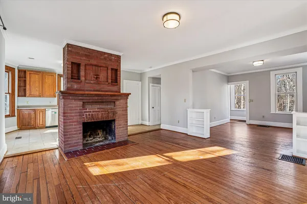 a living room with a fireplace and wooden floor