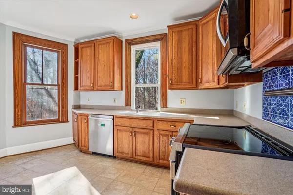 a kitchen that has a sink a stove and chair
