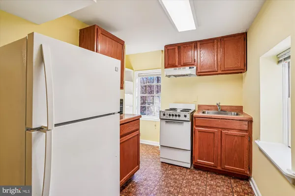 a kitchen with a refrigerator sink stove and cabinets