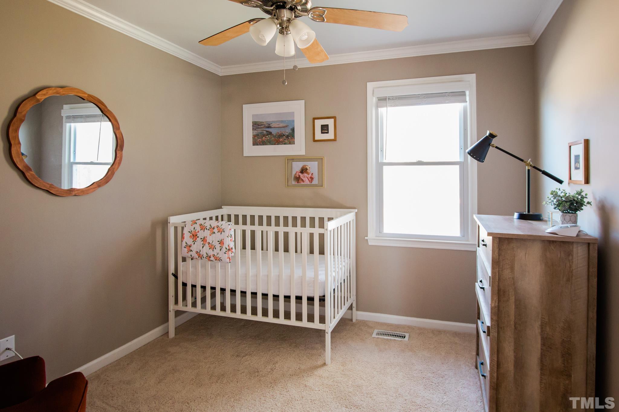 623 Little Creek Church Road Clayton, NC 27520 - Photo 22 of 47 a bedroom with a bed and a chandelier