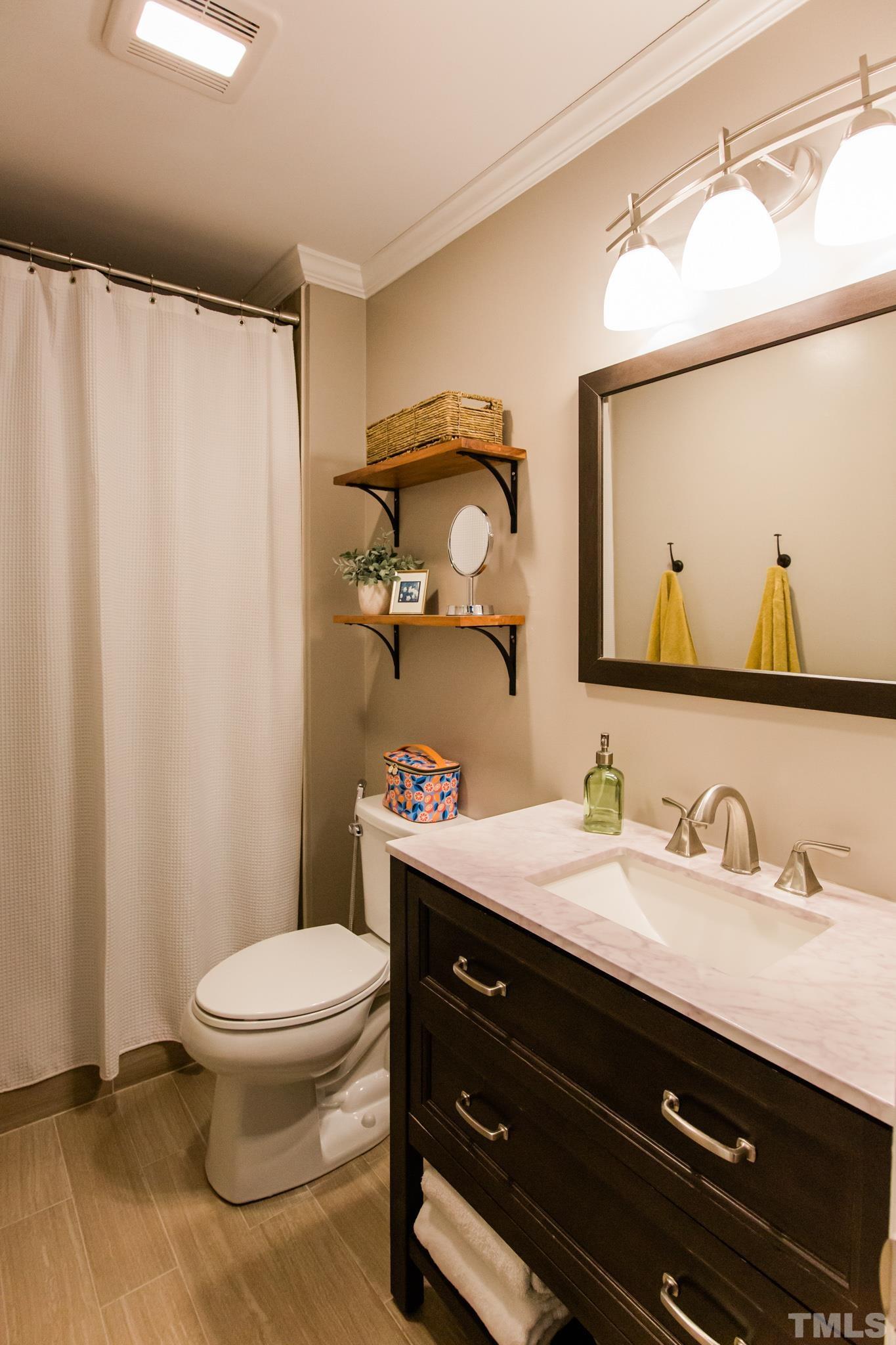 623 Little Creek Church Road Clayton, NC 27520 - Photo 40 of 47 a bathroom with a toilet a sink and a mirror