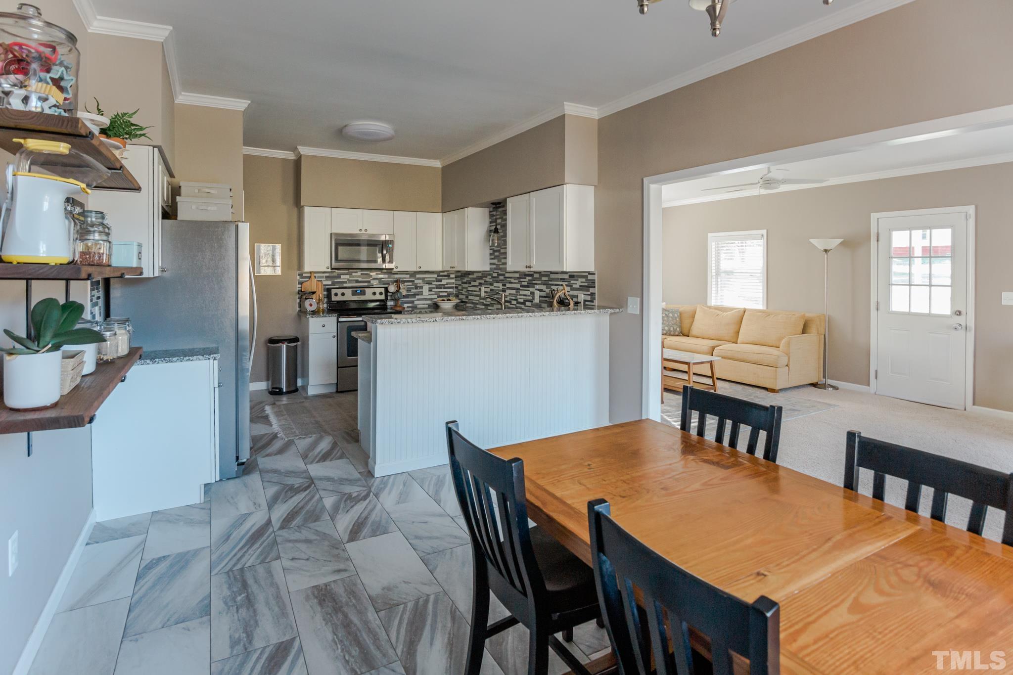 623 Little Creek Church Road Clayton, NC 27520 - Photo 4 of 47 a view of a dining room with furniture and wooden floor