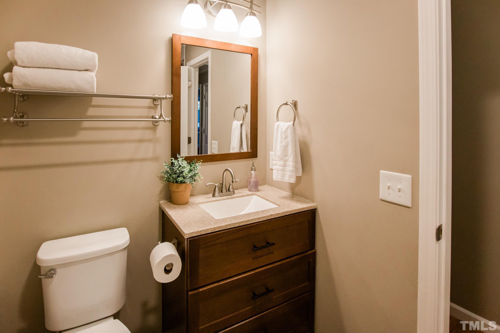 623 Little Creek Church Road Clayton, NC 27520 - Photo 42 of 47 a bathroom with a sink a toilet and mirror