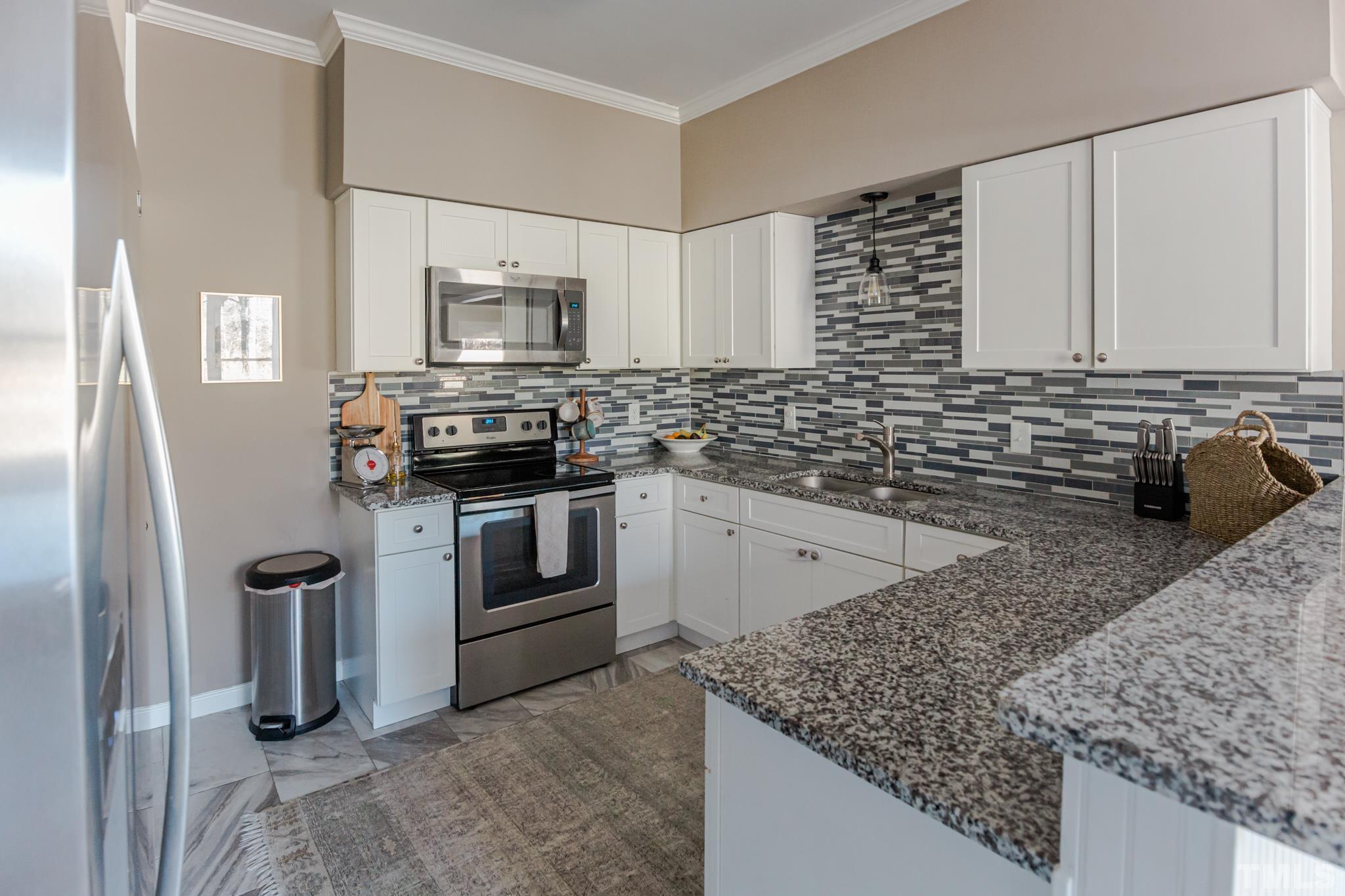 623 Little Creek Church Road Clayton, NC 27520 - Photo 5 of 47 a kitchen with stainless steel appliances granite countertop a sink stove and refrigerator