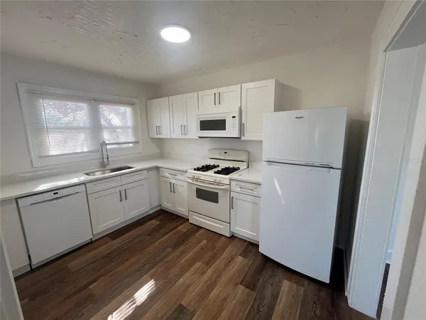 a kitchen with white cabinets and white appliances