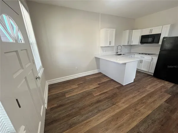 a view of kitchen with wooden floor and electronic appliances