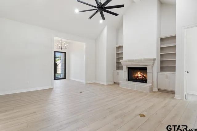 a view of an empty room with a fireplace and a window