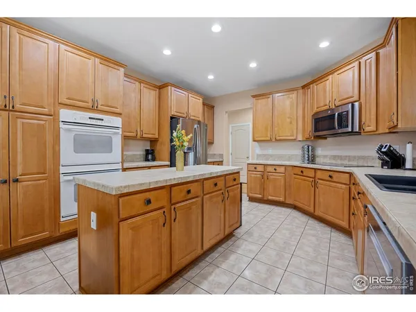 a kitchen with stainless steel appliances granite countertop a sink a stove and cabinets