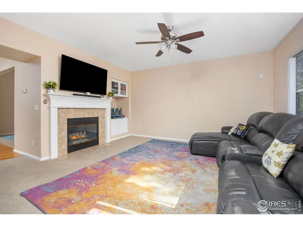 a living room with furniture a flat screen tv and a fireplace