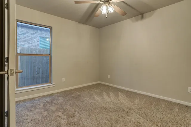 an empty room with a chandelier fan