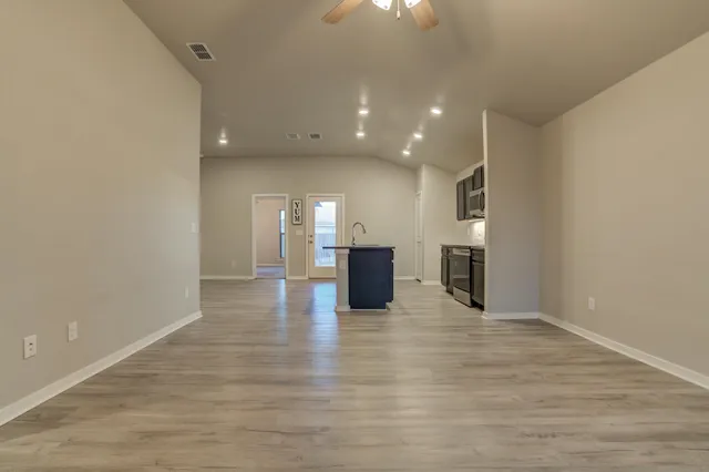 a view of a kitchen with a sink and an empty room