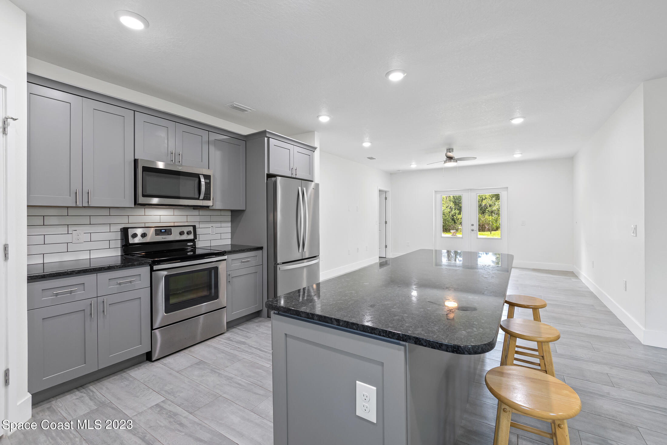 3685 Hield Road Melbourne, FL 32904 - Photo 8 of 24 a kitchen with granite countertop stainless steel appliances and wooden cabinets