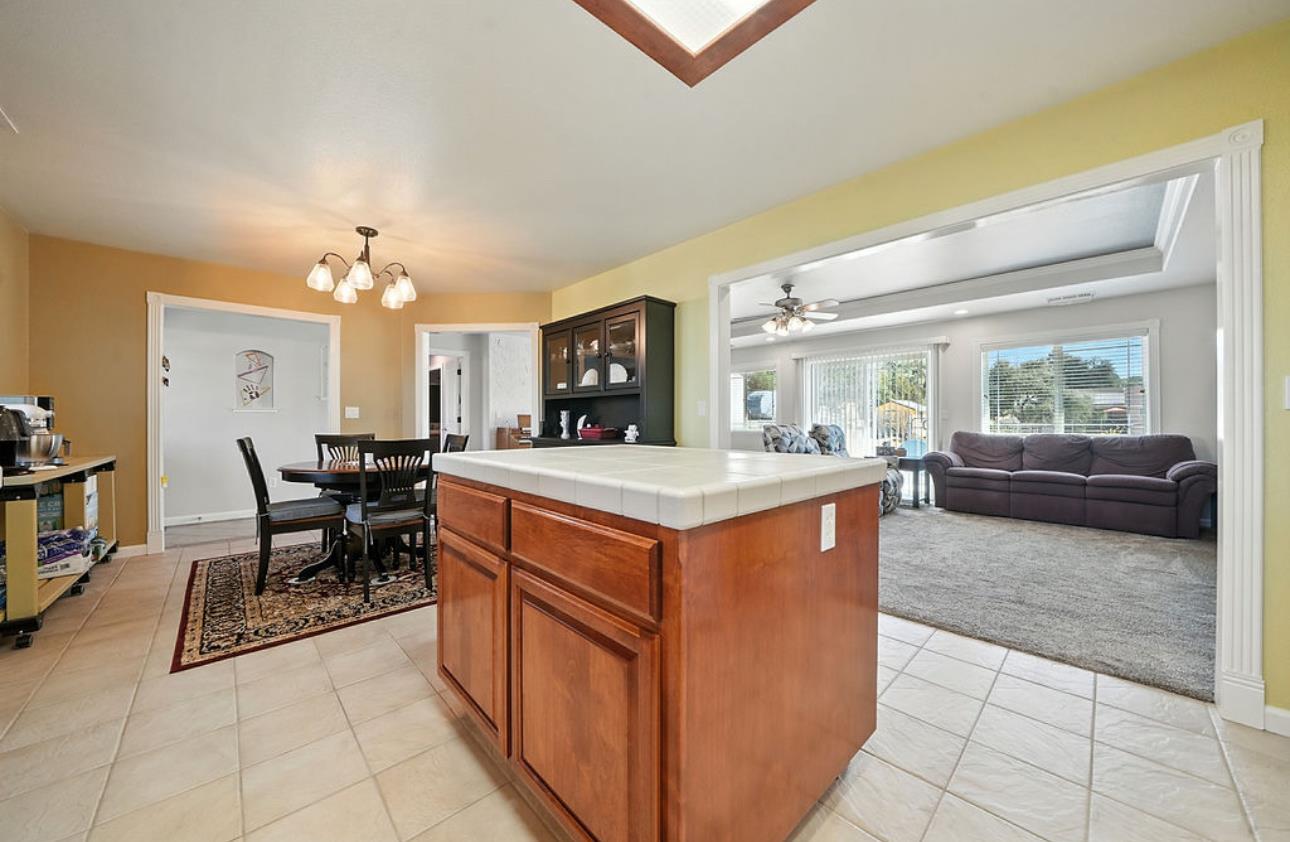 5825 Rippon Road Valley Springs, CA 95252 - Photo 19 of 45 a kitchen with stainless steel appliances granite countertop a stove top oven a dining table and chairs with the living room view