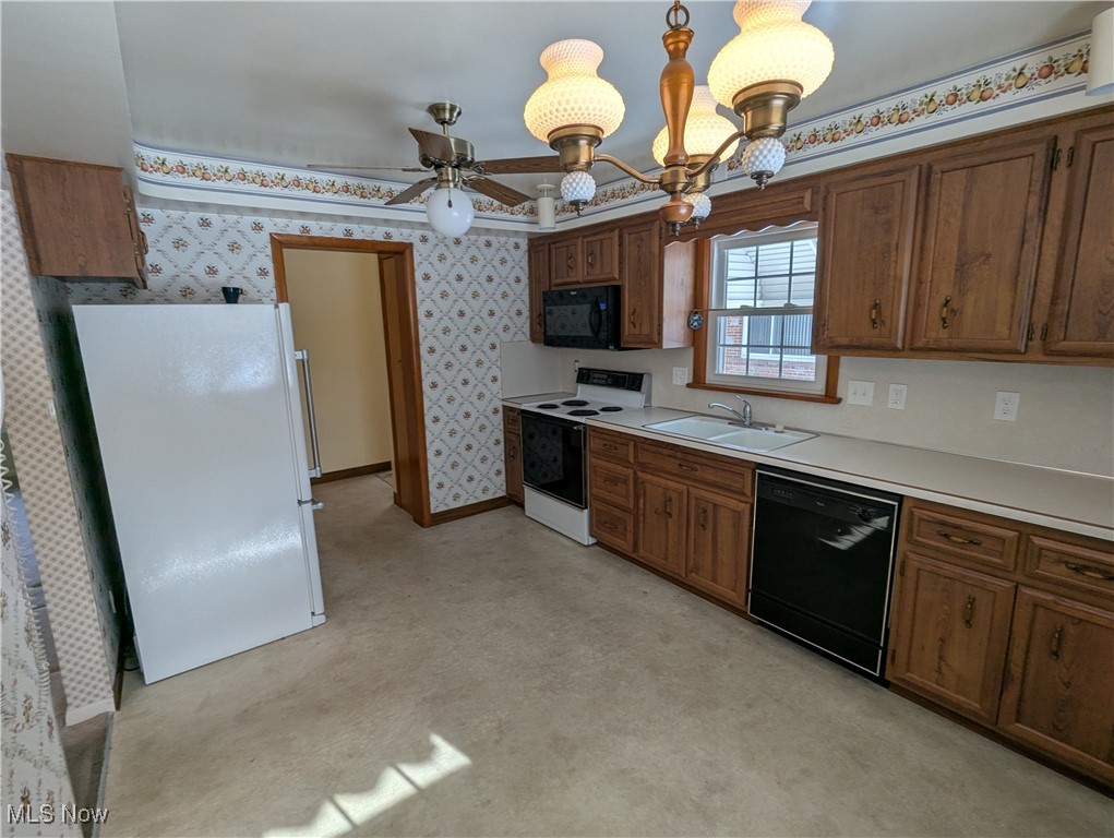 815 East Schaaf Road Independence, OH 44131 - Photo 9 of 36 Kitchen featuring ceiling fan with notable chandelier, sink, hanging light fixtures, and black appliances