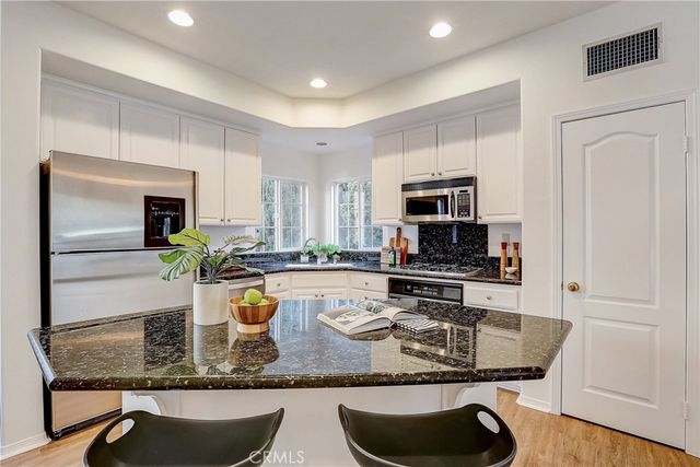 a kitchen with sink a microwave and cabinets