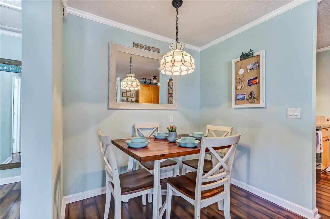 97253 Pirates Point Road Yulee, FL 32097 - Photo 12 of 34 a dining room with wooden floor a chandelier a wooden table and chairs