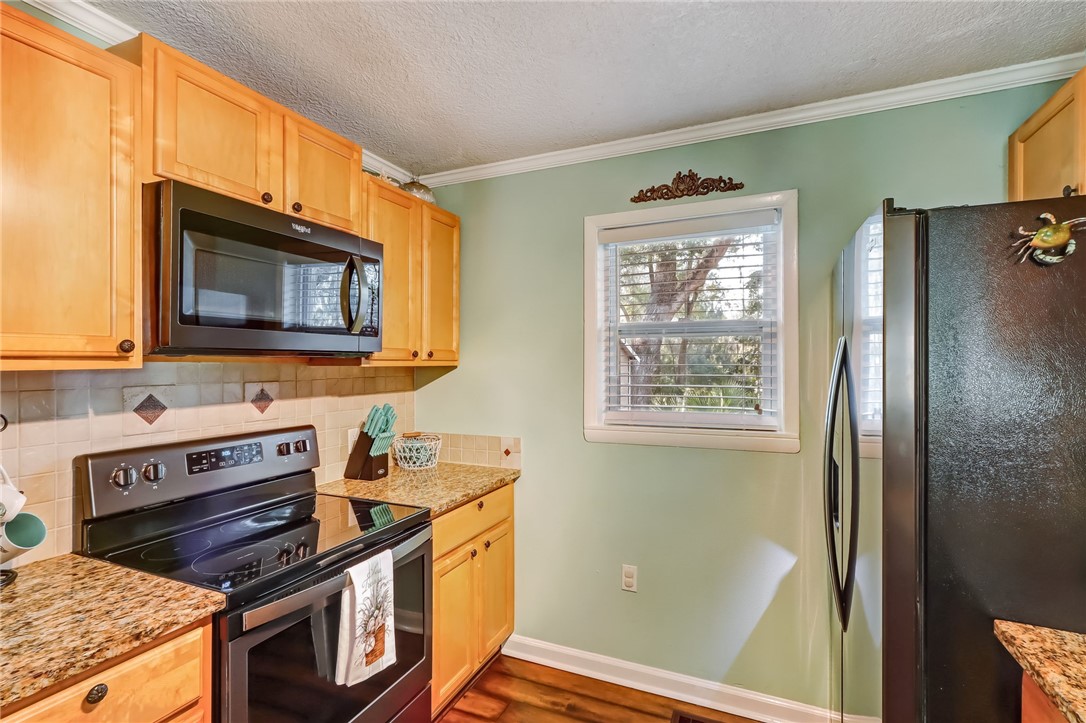 97253 Pirates Point Road Yulee, FL 32097 - Photo 14 of 34 a kitchen with stainless steel appliances granite countertop a stove a sink and a microwave