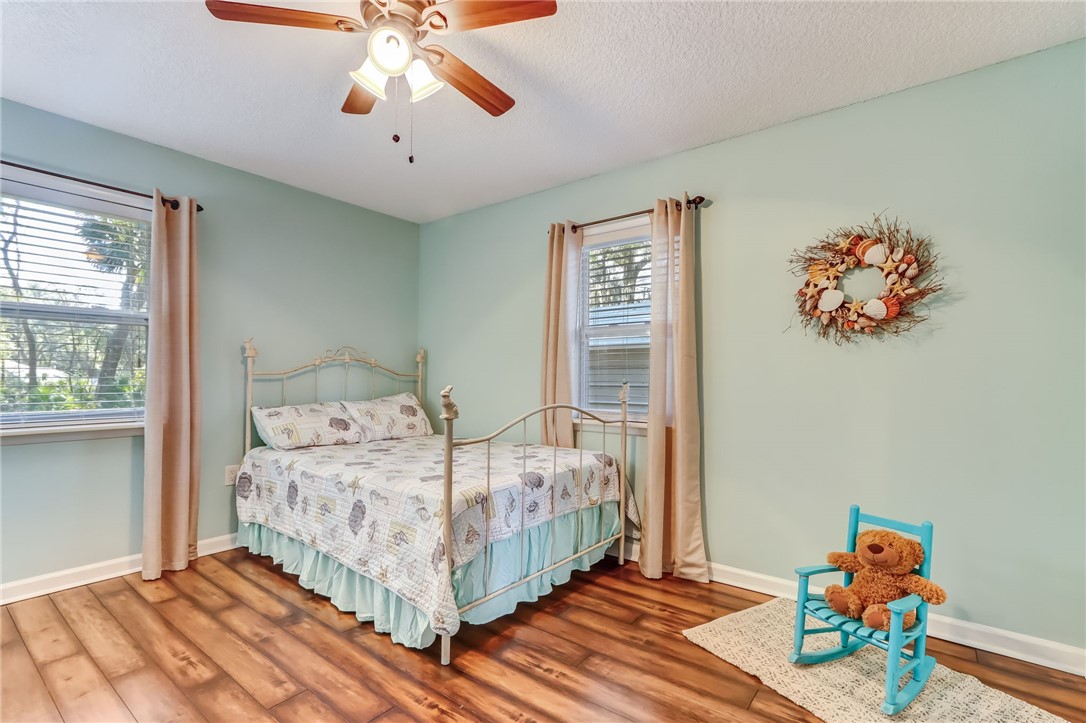 97253 Pirates Point Road Yulee, FL 32097 - Photo 17 of 34 a bedroom with a bed and a chandelier