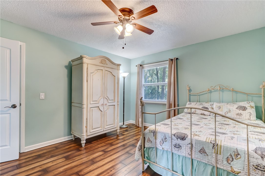 97253 Pirates Point Road Yulee, FL 32097 - Photo 18 of 34 a bedroom with a bed and a chandelier