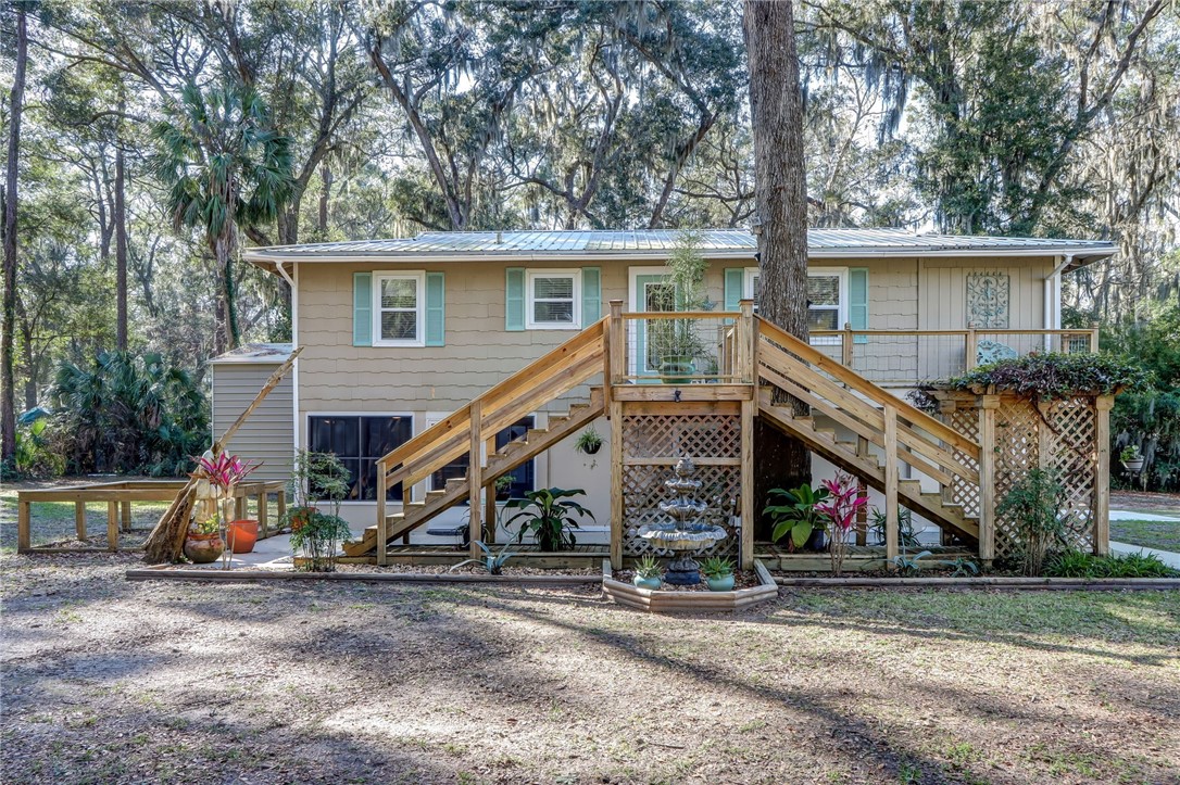 97253 Pirates Point Road Yulee, FL 32097 - Photo 7 of 34 a view of a house with a yard and a wooden deck