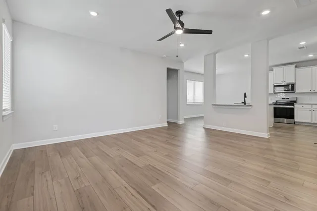 wooden floor in an empty room with a kitchen