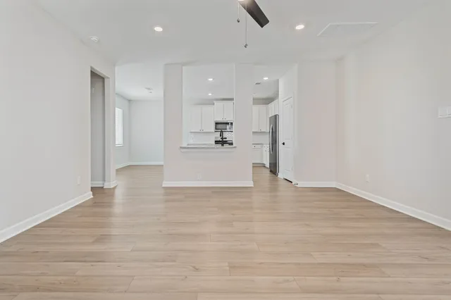 a view of a kitchen with refrigerator and white cabinets