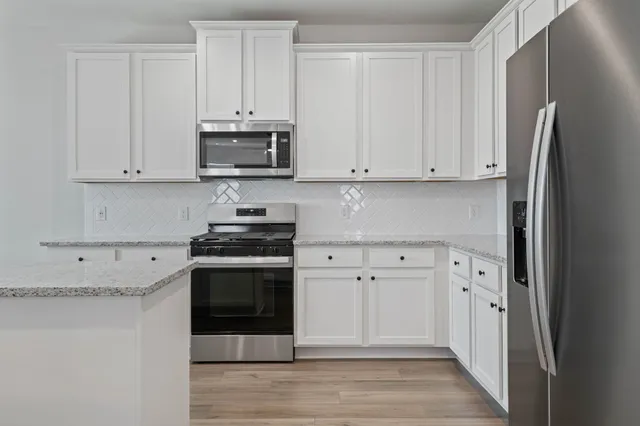 a kitchen with stainless steel appliances granite countertop a stove and a refrigerator