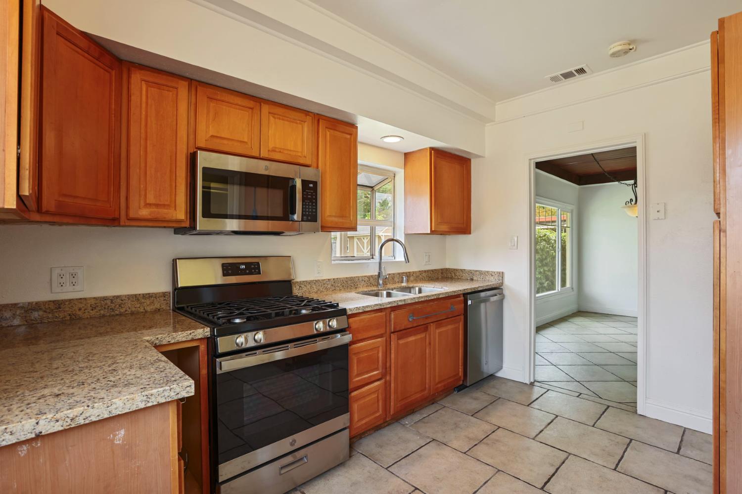 2452 Christina Avenue Stockton, CA 95204 - Photo 11 of 34 a kitchen with stainless steel appliances granite countertop a stove sink and microwave