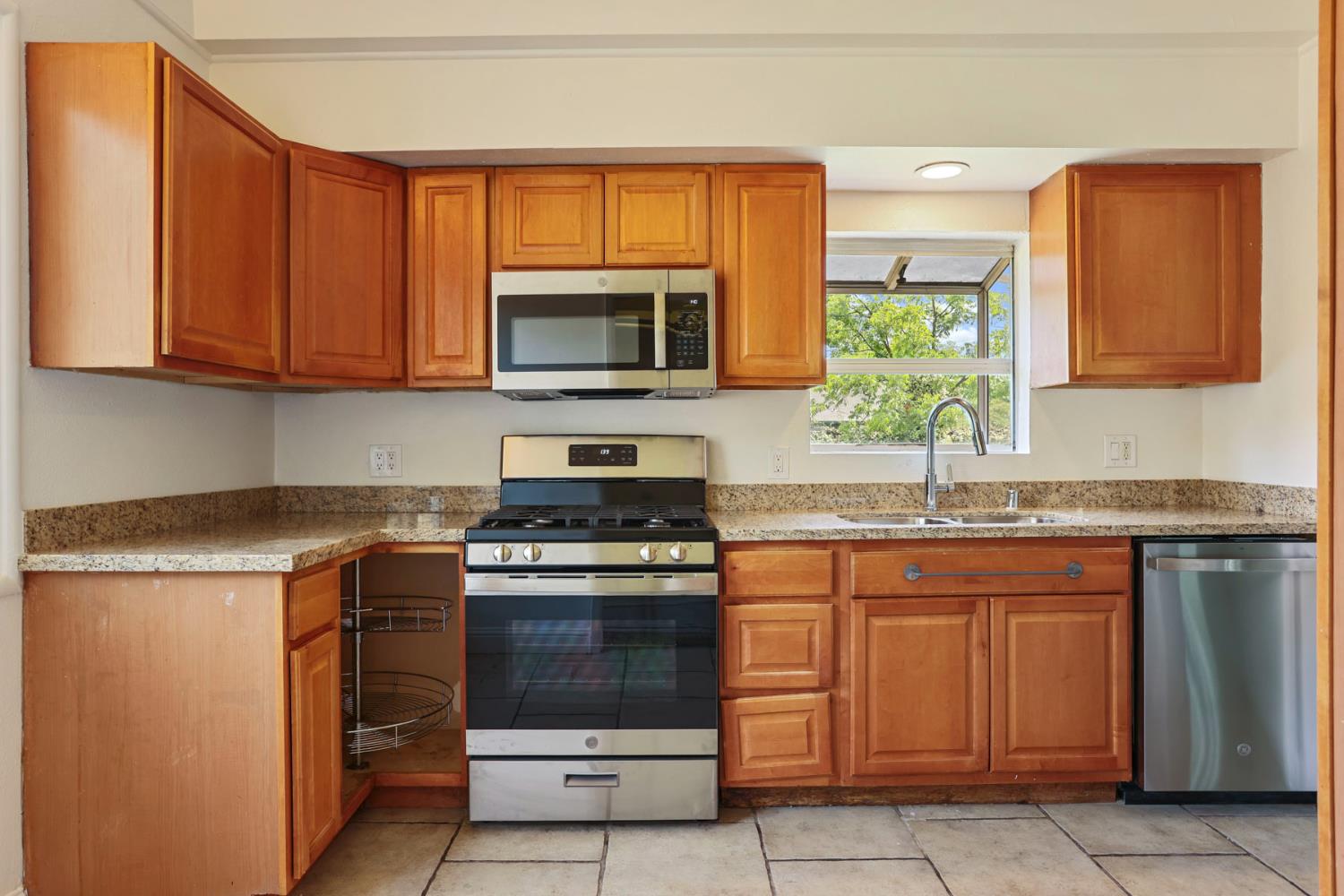 2452 Christina Avenue Stockton, CA 95204 - Photo 13 of 34 a kitchen with granite countertop a stove top oven microwave and cabinets