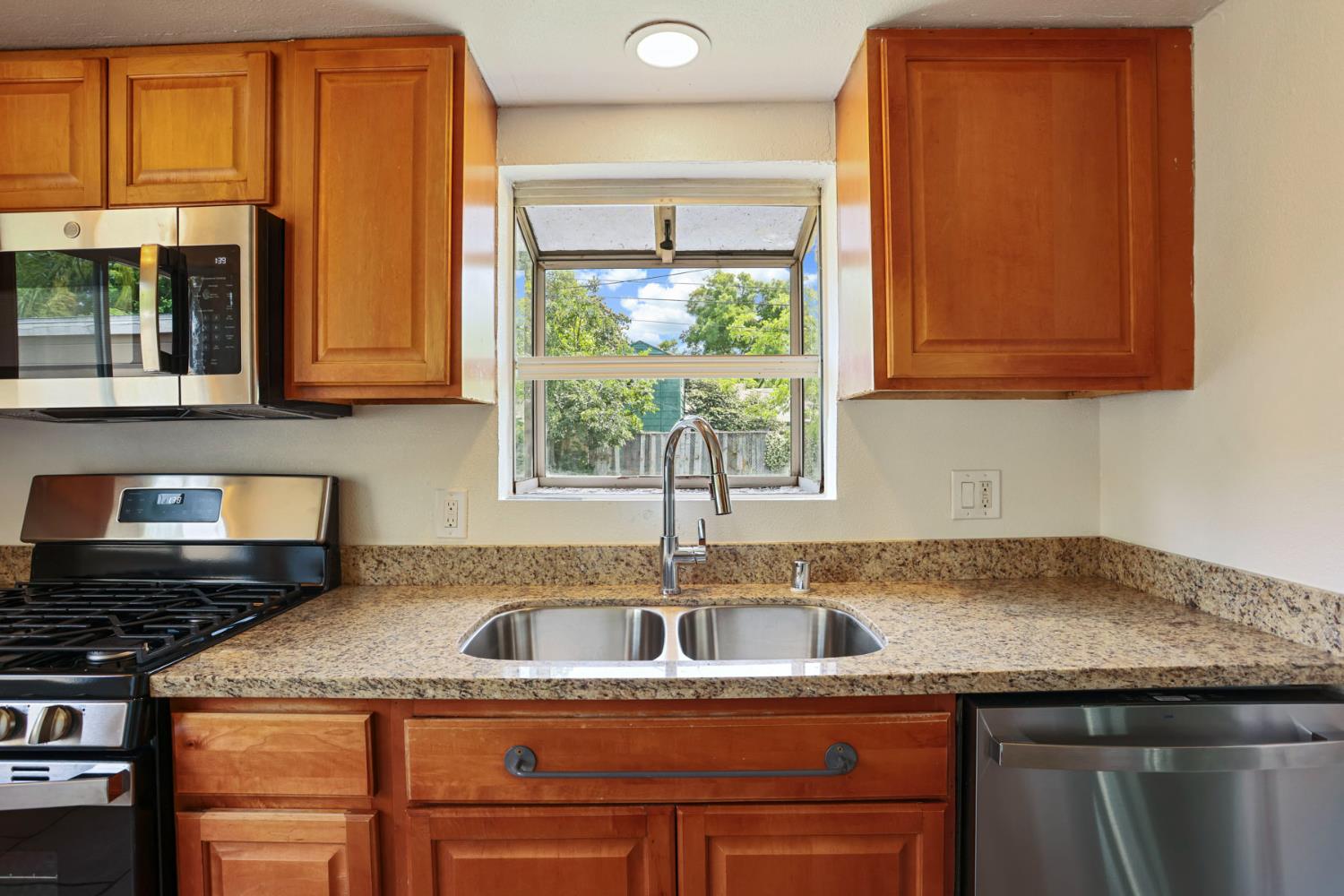 2452 Christina Avenue Stockton, CA 95204 - Photo 10 of 34 a kitchen with granite countertop a sink and a window