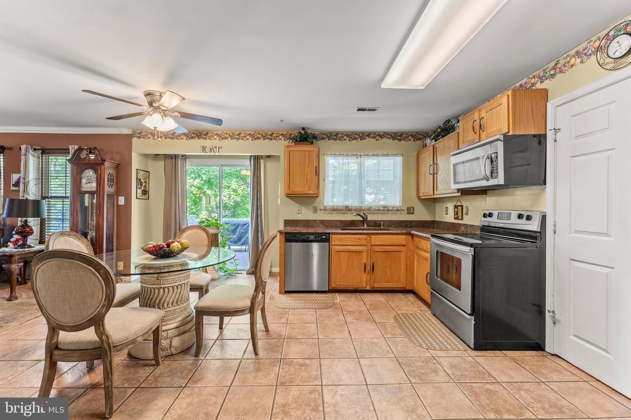 8910 Edison Lane Clinton, MD 20735 - Photo 17 of 51 a kitchen with granite countertop a stove a sink cabinetry a dining table and chairs