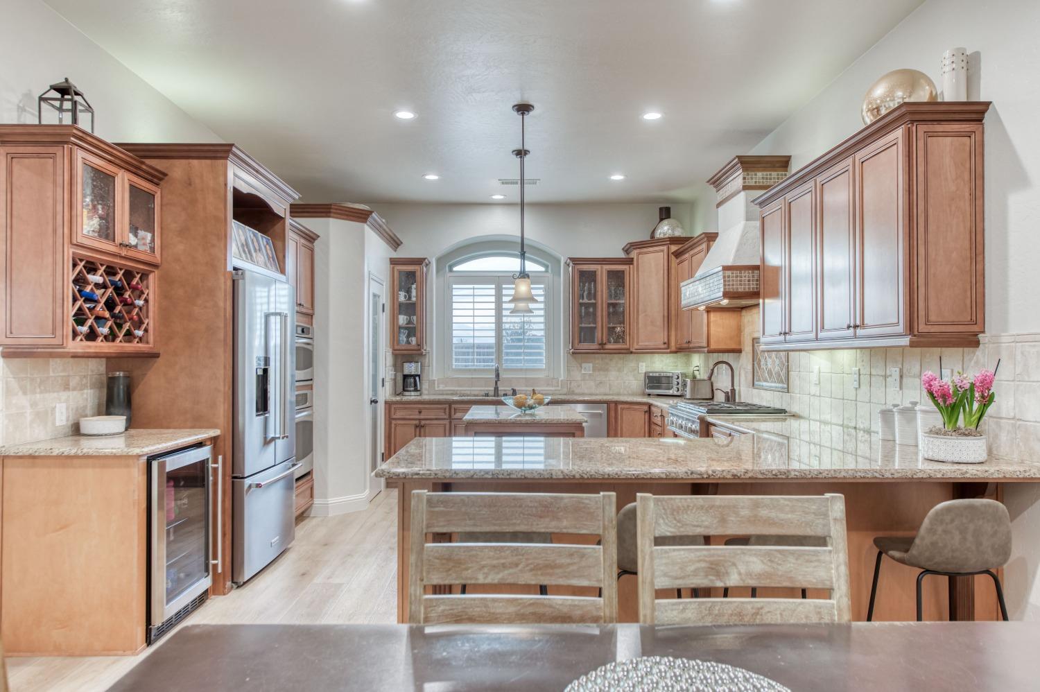 1674 North Cindy Avenue Clovis, CA 93619 - Photo 12 of 46 a kitchen with kitchen island granite countertop a large counter top stainless steel appliances and cabinets