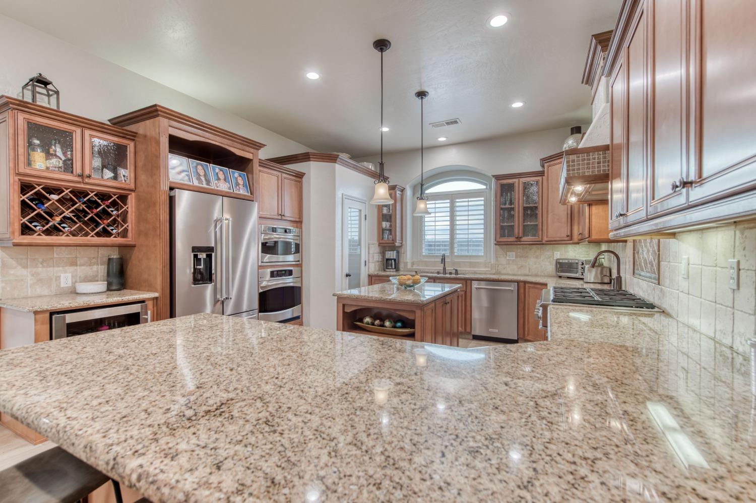 1674 North Cindy Avenue Clovis, CA 93619 - Photo 14 of 46 a kitchen with stainless steel appliances granite countertop a stove a sink and a refrigerator