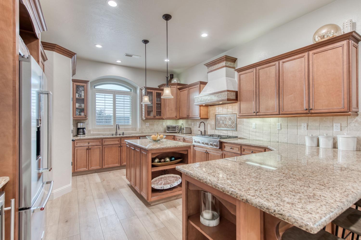 1674 North Cindy Avenue Clovis, CA 93619 - Photo 15 of 46 a kitchen with granite countertop a stove a sink a refrigerator and wooden cabinets