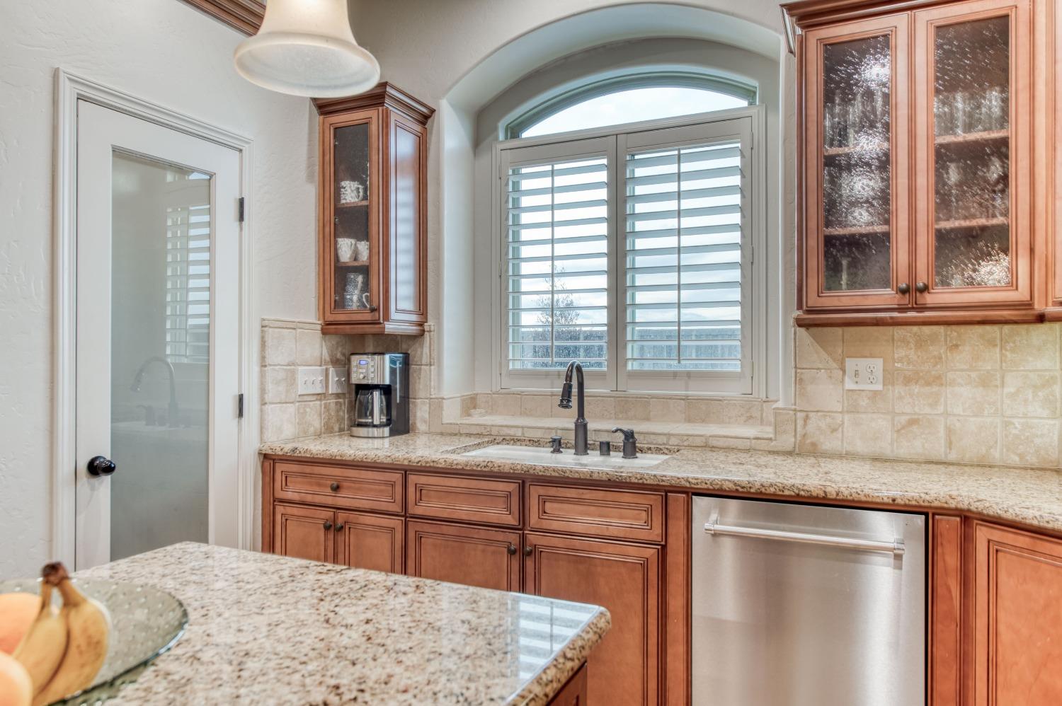1674 North Cindy Avenue Clovis, CA 93619 - Photo 20 of 46 a kitchen with kitchen island granite countertop a sink stainless steel appliances cabinets and a counter top space