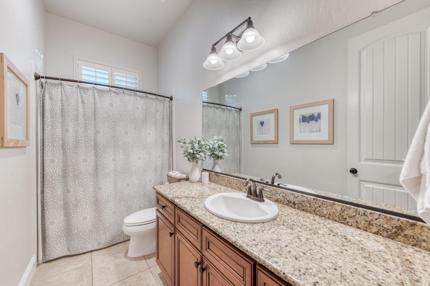 1674 North Cindy Avenue Clovis, CA 93619 - Photo 26 of 46 a bathroom with a granite countertop sink toilet and shower