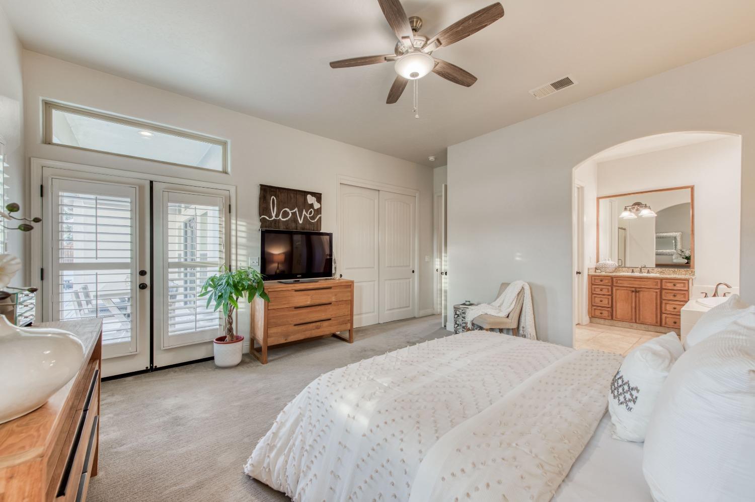 1674 North Cindy Avenue Clovis, CA 93619 - Photo 28 of 46 a bedroom with a large bed and a chandelier