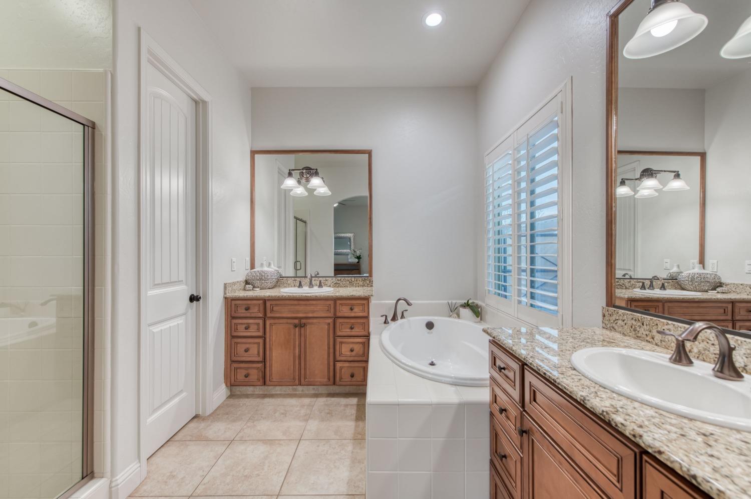 1674 North Cindy Avenue Clovis, CA 93619 - Photo 29 of 46 a bathroom with a granite countertop double vanity sink mirror bathtub and shower