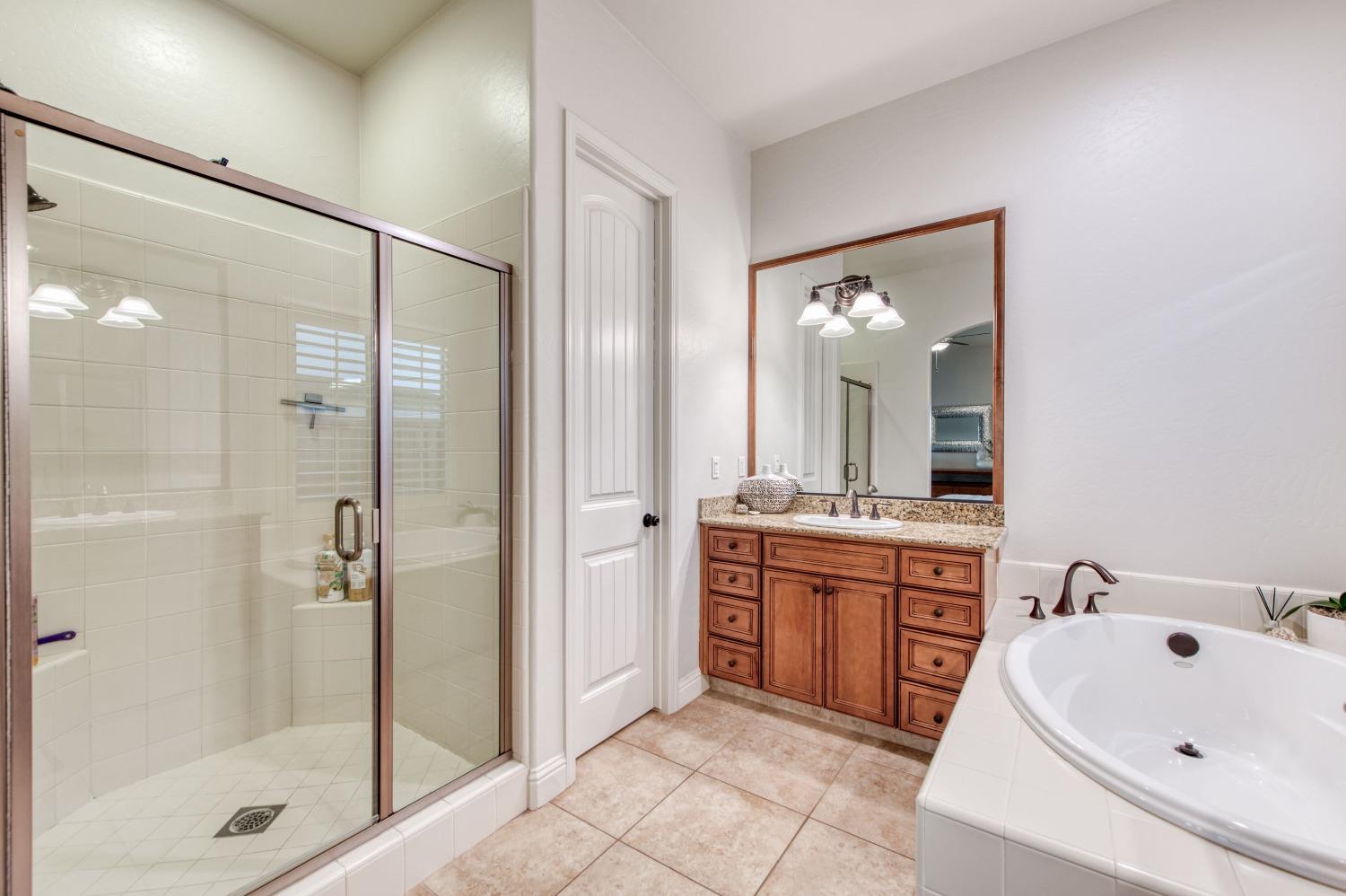 1674 North Cindy Avenue Clovis, CA 93619 - Photo 30 of 46 a spacious bathroom with a shower sink and mirror