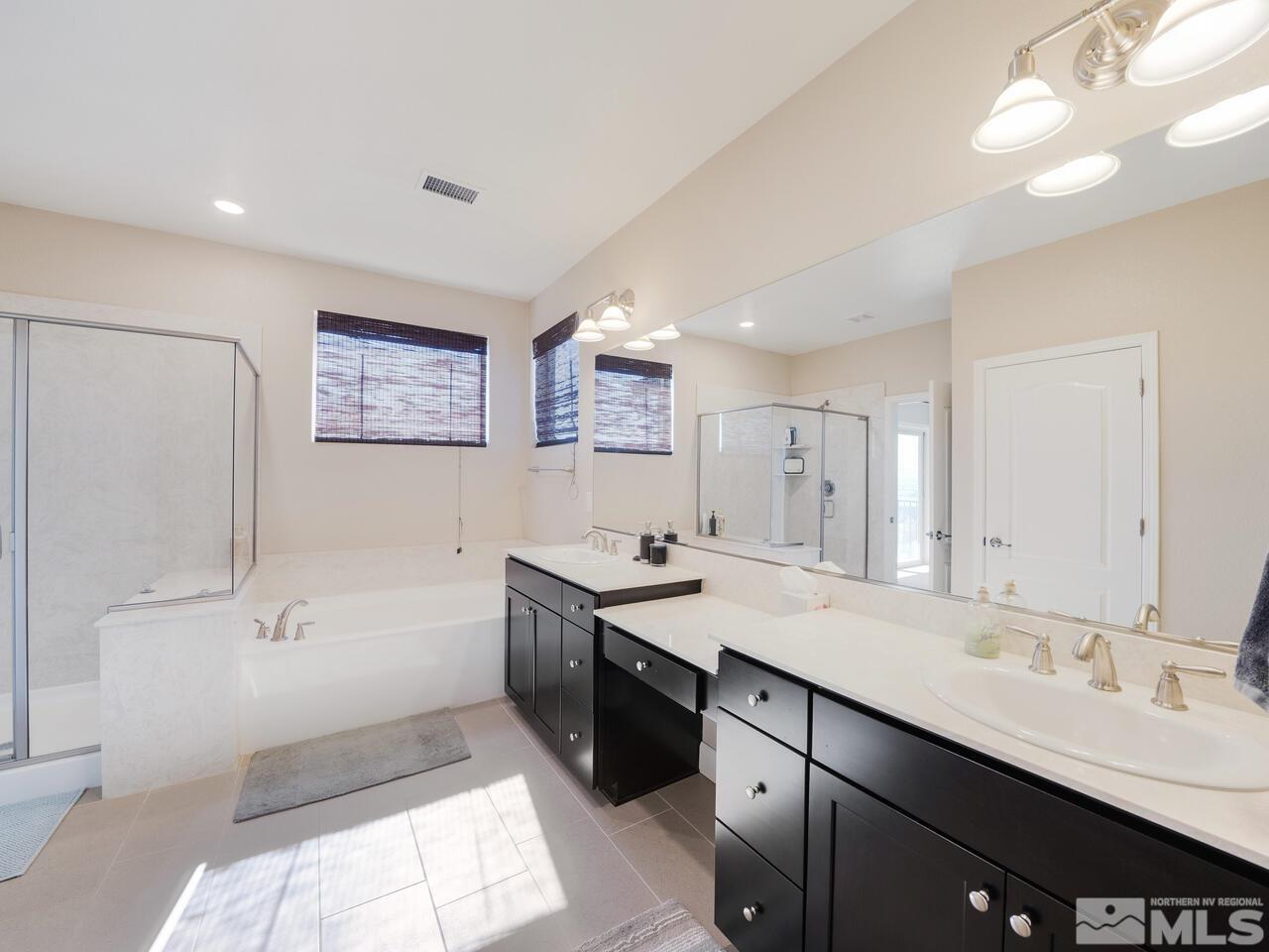9050 Sydmesa Drive Reno, NV 89523 - Photo 14 of 23 a spacious bathroom with a bathtub sink mirror and toilet