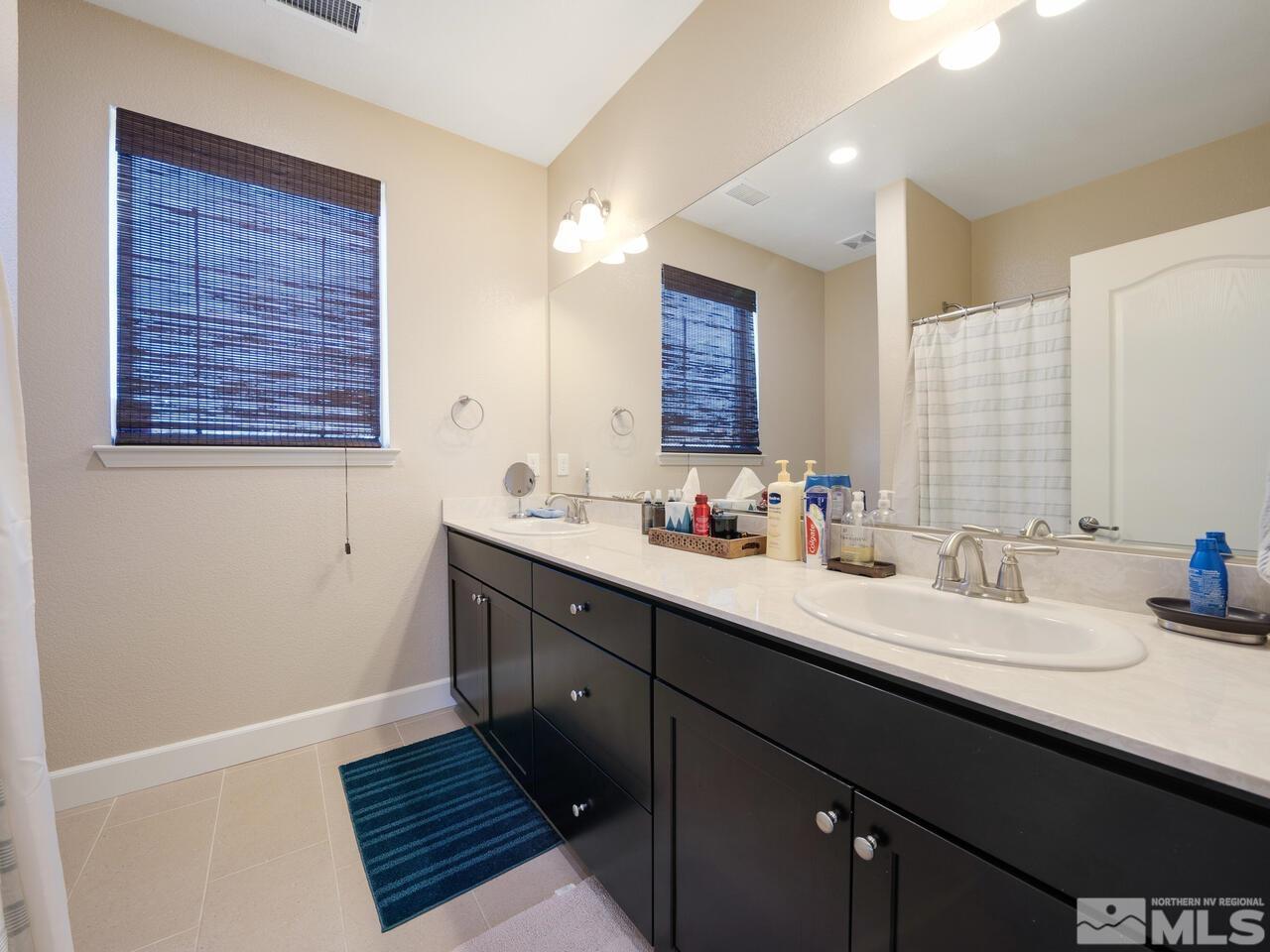9050 Sydmesa Drive Reno, NV 89523 - Photo 16 of 23 a bathroom with a double vanity sink and a mirror