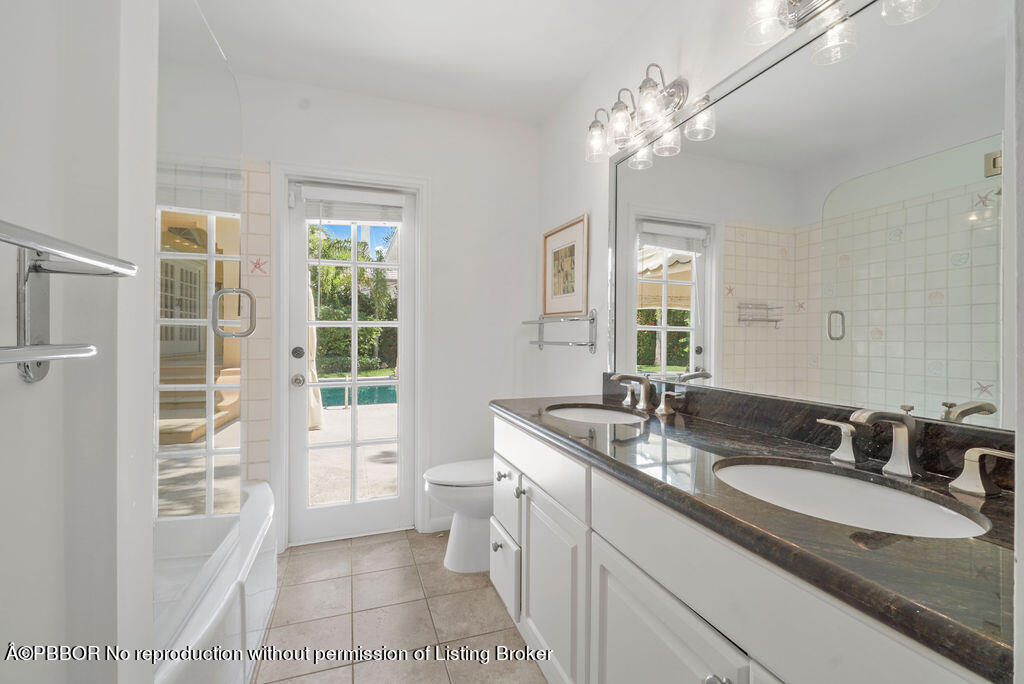 257 Fairview Road Palm Beach, FL 33480 - Photo 13 of 30 a spacious bathroom with a granite countertop sink a large mirror and a shower