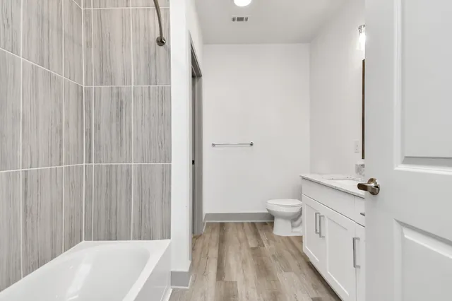 a bathroom with a toilet a sink and tub